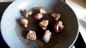 Lamb heart being coloured in a frying pan. Mushrooms, cleaned and chopped into chunks.